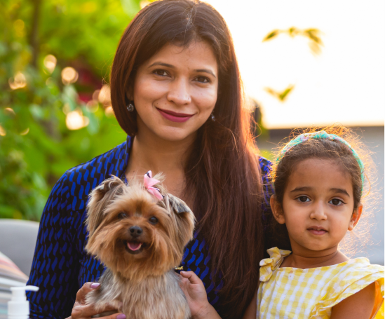A pet mom holding her pet dog and her little girl